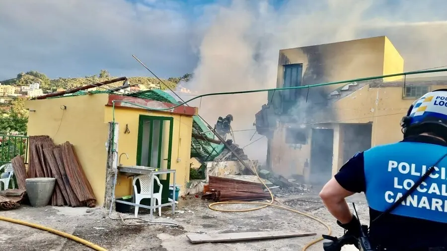 Un agente de la Polic&iacute;a Local de La Laguna observa el derrumbe de una vivienda tras un incendio