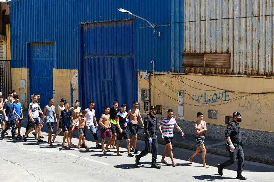 Archivo - Un grupo de j&oacute;venes migrantes marroqu&iacute;es en fila en las inmediaciones de una nave, a 17 de mayo de 2021, en Ceuta (Espa&ntilde;a). La delegaci&oacute;n ha cifrado que unas 1000 personas, de las que al menos 300 son menores de edad, han conseguido sortear los 