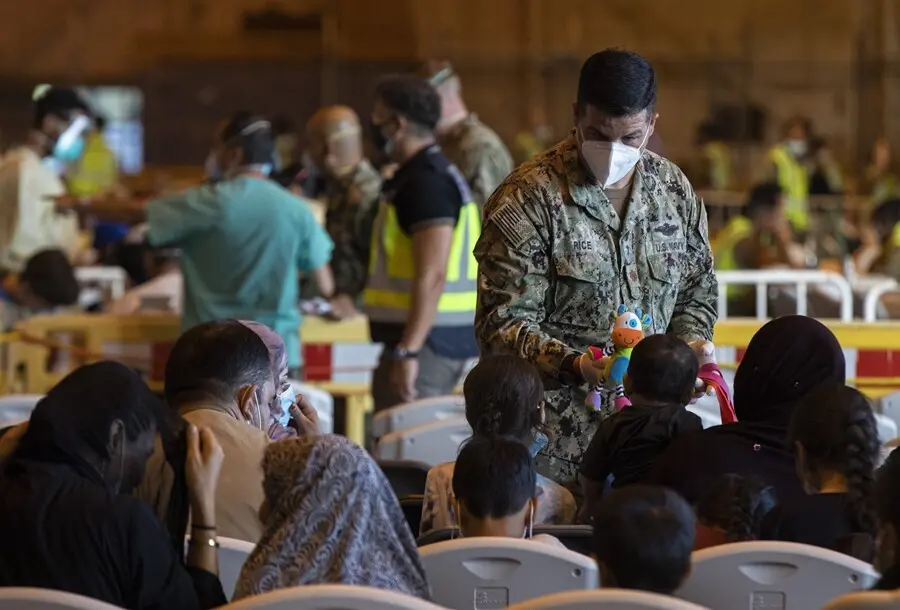 Un militar de Estados Unidos ofrece un mu&ntilde;eco a un ni&ntilde;o afgano en la Base Naval de Rota.