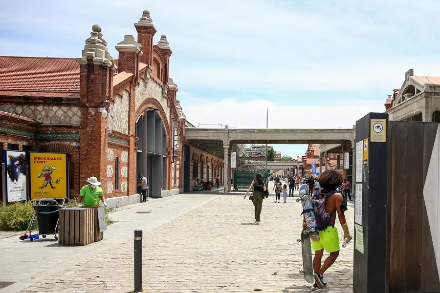 Archivo - Un hombre camina con varios monopatines en Matadero-Madrid