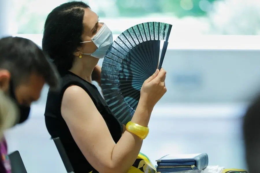 Archivo - Una mujer con mascarilla se abanica en Madrid