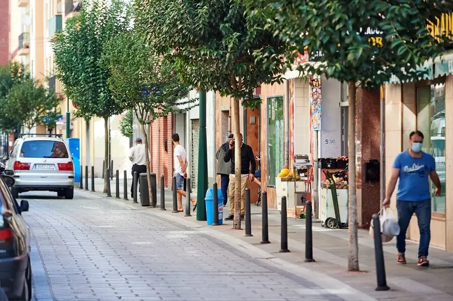Archivo - Transe&uacute;ntes pasean por las calles del barrio La Inmobiliaria de Torrelavega, en Cantabria.- Archivo