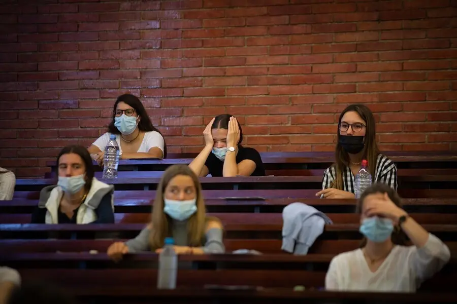Archivo - Estudiantes esperando antes del primer examen de las pruebas de acceso a la universidad (PAU), en la Facultad de Econom&iacute;a y Empresa de la UB