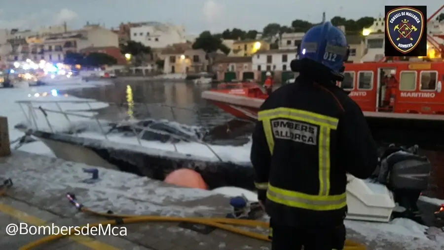 Un bombero frente a la embarcaci&oacute;n incendiada en Portopetro.