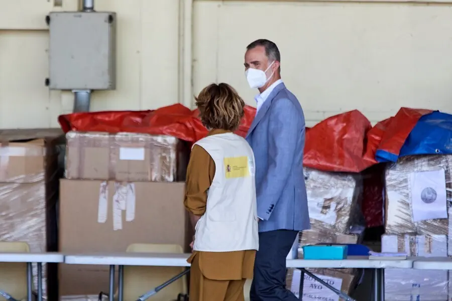 El Rey Felipe VI conversa con una cooperante a su llegada al hangar para visitar el dispositivo provisional en Torrej&oacute;n de Ardoz