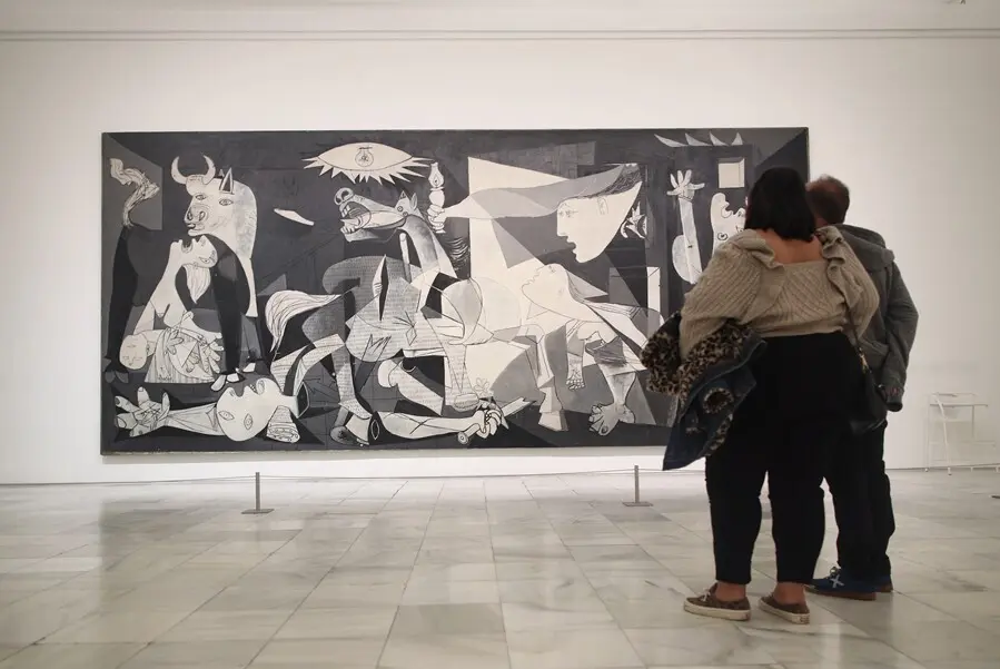 Archivo - Dos personas observan el 'Guernica' de Pablo Picasso en una de las salas del Museo Reina Sof&iacute;a 