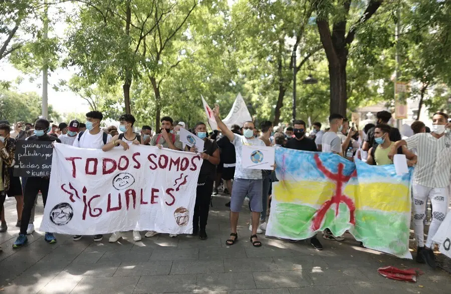 Varias personas con una pancarta en la que se lee: `Todos somos iguales&acute;, en una concentraci&oacute;n frente al Ministerio del Interior para exigir la reforma del Reglamento de Extranjer&iacute;a.