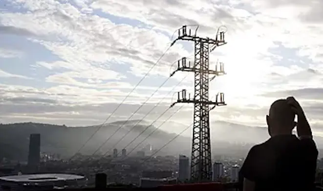 Una persona observa el cableado con el que red el&eacute;ctrica transporta la energ&iacute;a sobre la ciudad de Bilbao.Luis TejidoEFE