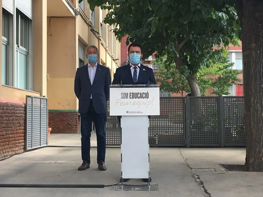 El presidente de la Generalitat, Pere Aragon&egrave;s, y el conseller de Educaci&oacute;n, Josep Gonz&agrave;lez-Cambray (detr&aacute;s), en una rueda de prensa en la Escola Tanit de Santa Coloma de Gramenet (Barcelona) el primer d&iacute;a del curso 2021-2022