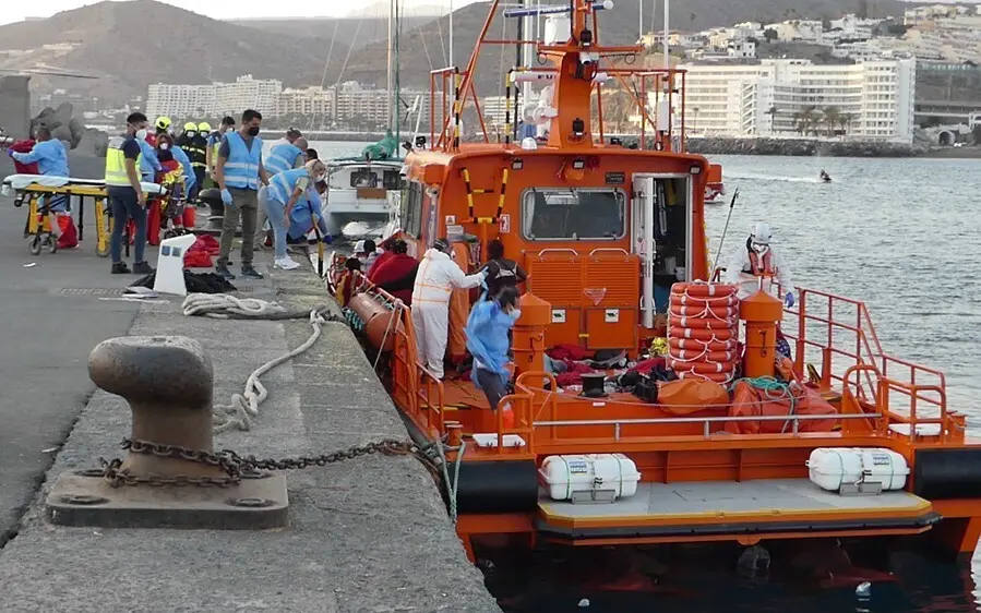 Agentes de salvamento mar&iacute;timo ayudan a un hombre migrante a desembarcar a 26 de agosto de 2021, en Arguinegu&iacute;n (Gran Canaria)