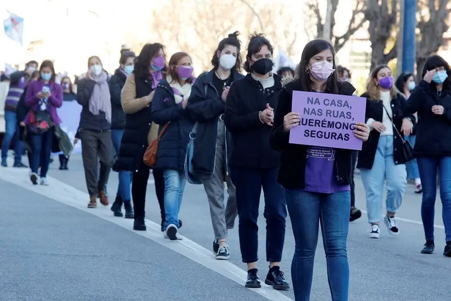 Archivo - Una mujer sostiene una pancarta donde se lee "En casa, en las calles, nos queremos seguras".