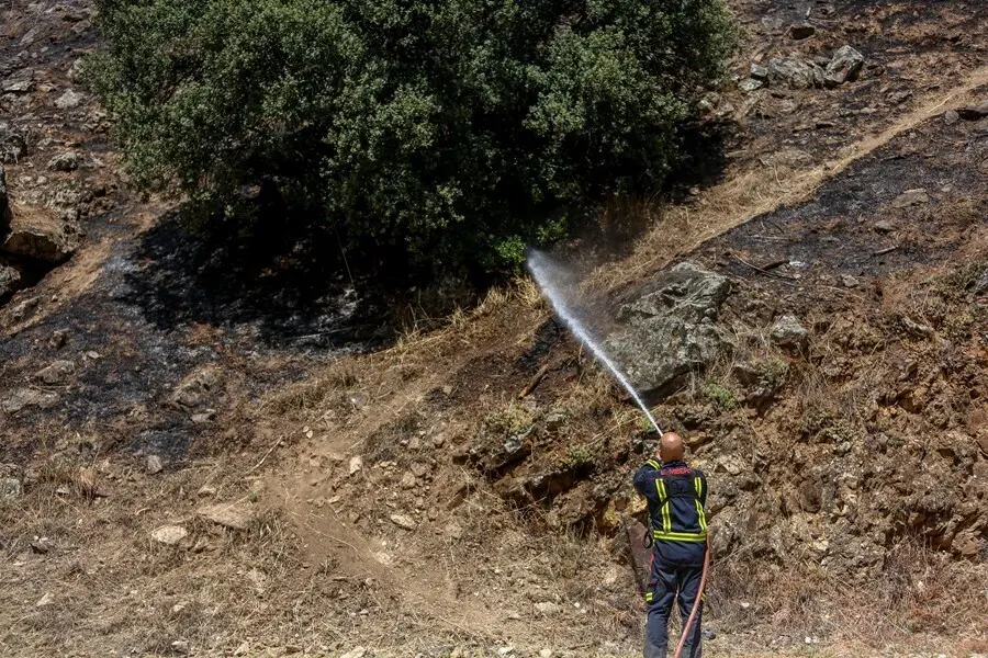 Archivo - Un bombero trabaja en la extinci&oacute;n de uno de los focos del incendio del pantano de San Juan.