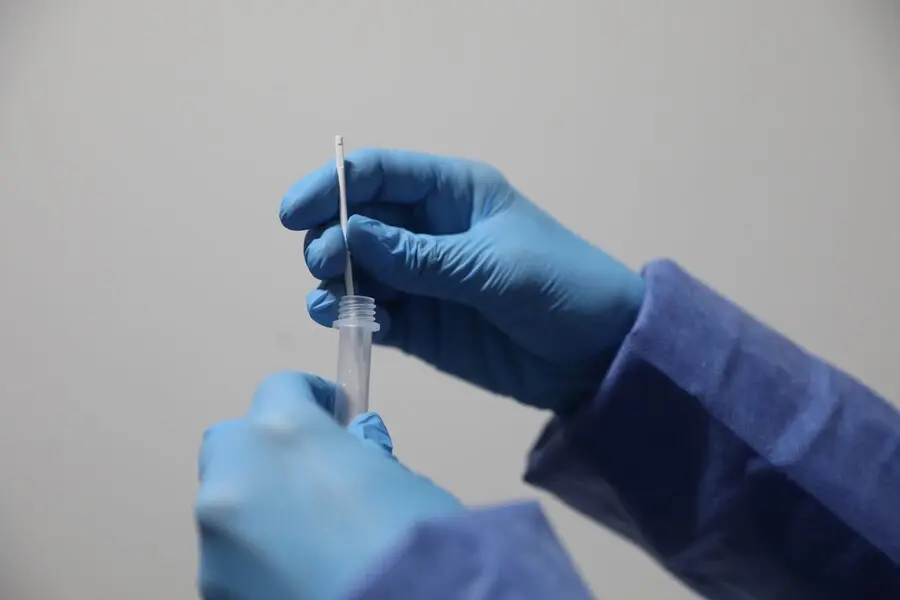 Archivo - Un sanitario sostiene una probeta tras realizar un test de ant&iacute;genos