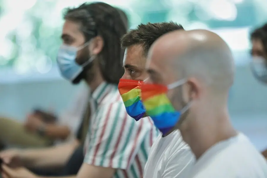 Archivo - Dos hombres se protegen con mascarillas con la bandera LGTB durante su participaci&oacute;n en el acto institucional con motivo del Orgullo 2020, en Madrid (Espa&ntilde;a), a 29 de junio de 2020.