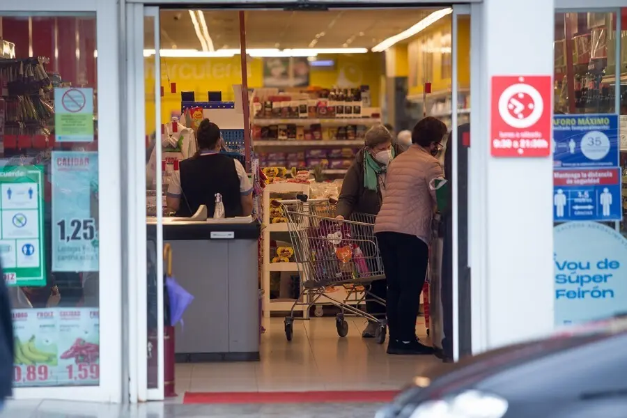 Archivo - Varias personas compran en un supermercado 