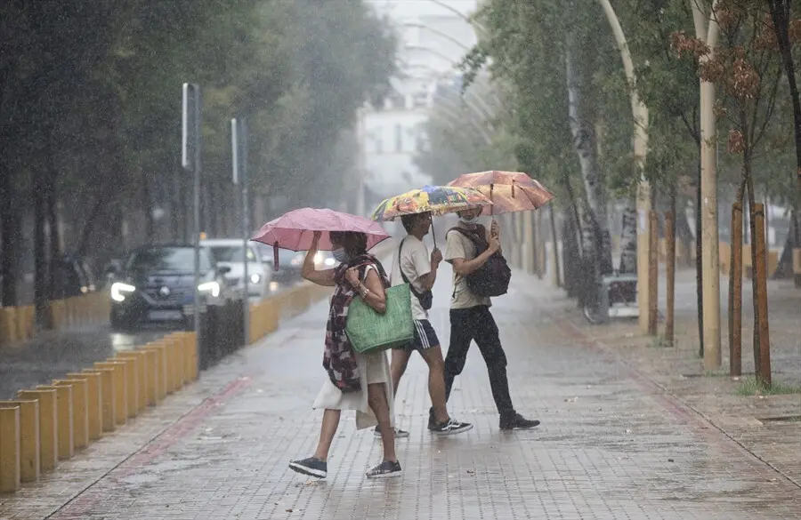 Varias personas caminan bajo sus paraguas durante una tormenta. A 14 de septiembre de 2021, en Sevilla (Andaluc&iacute;a, Espa&ntilde;a).