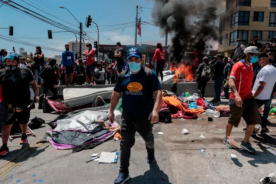 Grupo de personas queman carpas que eran utilizadas por extranjeros para pernoctar en plazas y playas, durante una marcha contra la migraci&oacute;n irregular hoy, en Iquique (Chile). Una multitudinaria marcha contra la migraci&oacute;n irregular realizada este s&aacute;bado en Iquique, en el norte de Chile, termin&oacute; con incidentes violentos en contra de extranjeros que se encuentran varados en la ciudad a la espera de regularizar su situaci&oacute;n. EFE/ Johan Berna