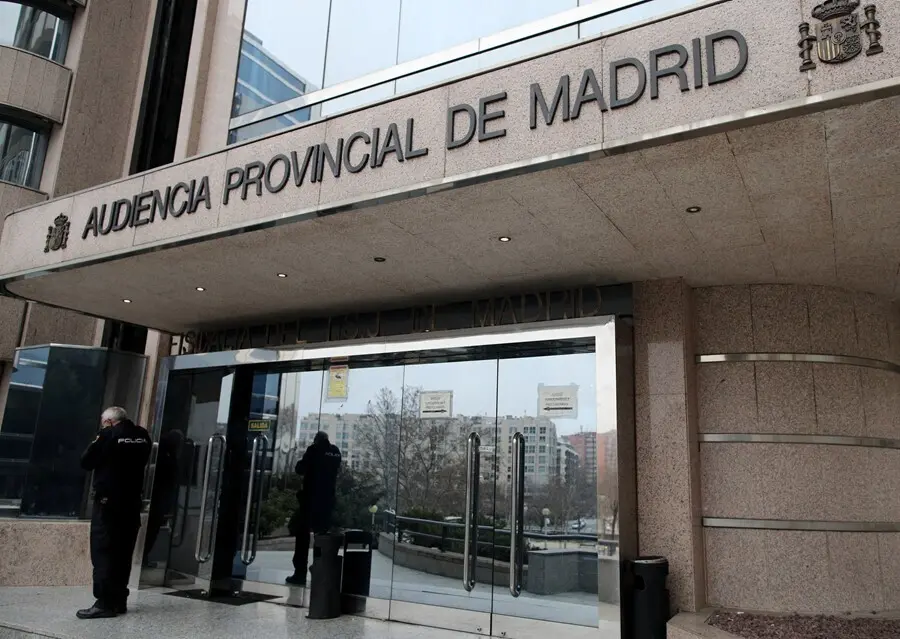 Archivo - Un agente de la Polic&iacute;a Nacional junto a la puerta principal de la Audiencia Provincial de Madrid, a 14 de febrero de 2020.