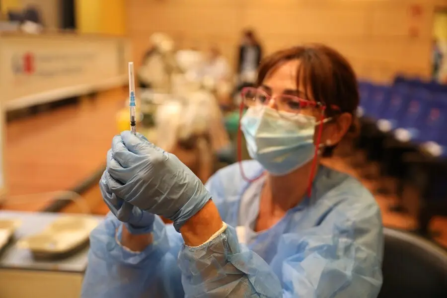 Archivo - Una sanitaria prepara una vacuna contra el coronavirus.