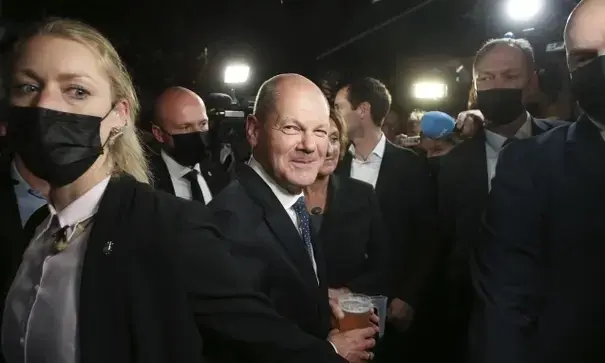Olaf Scholz (centro) bebe una cerveza al salir de la fiesta electoral en la Casa Willy Brandt de Berl&iacute;n. Fotograf&iacute;a: Wolfgang Kumm/AP