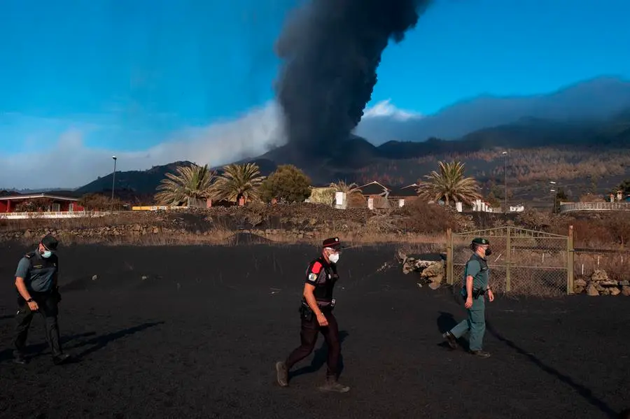 Un agente de la Polic&iacute;a Canarias y dos de la Guardia Civil patrullan este lunes por el barrio de Las Manchas, en La Palma, dentro de la zona evacuada por su proximidad al volc&aacute;n y a sus emisiones de lava, ceniza y piroclastos. EFE/Carlos de Sa&aacute;