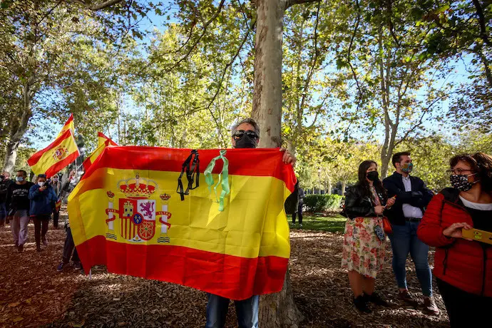 Varias personas se concentran con banderas de Espa&ntilde;a en apoyo a la figura de Felipe VI a las puertas del Palacio Real mientras se celebra el acto militar con motivo del D&iacute;a de la Fiesta Nacional o D&iacute;a de la Hispanidad, en Madrid (Espa&ntilde;a), a 12 de octubre de 2020. La celebraci&oacute;n este a&ntilde;o es mucho m&aacute;s &iacute;ntima sin el tradicional desfile por el Paseo de la Castellana, en un d&iacute;a en el que se conmemora la efem&eacute;ride hist&oacute;rica del descubrimiento de Am&eacute;rica por parte de Espa&ntilde;a.
12 OCTUBRE 2020;APOYO MONARQU&Iacute;A;REY;HISPANIDAD;FIESTA NACIONAL
Ricardo Rubio / Europa Press
  (Foto de ARCHIVO)
12/10/2020