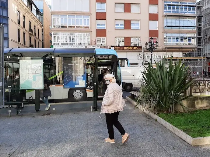 Una persona con mascarilla se dispone a tomar el bus en el centro de Santander. / S. D&iacute;az