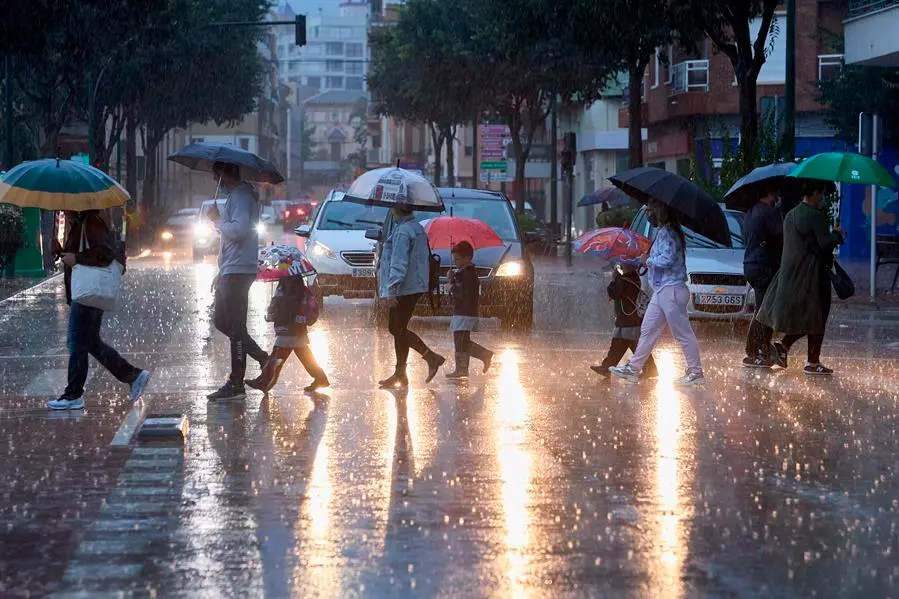 Varias personas cruzan una calle bajo la lluvia cuando el litoral sur de Valencia y norte de Alicante est&aacute; en preemergencia nivel naranja por lluvias durante hoy viernes y el fin de semana en la Comunitat Valenciana se presenta con lluvias durante el s&aacute;bado, mientras que para el domingo el cielo estar&aacute; poco nuboso y se espera un ligero aumento de las temperaturas m&aacute;ximas. EFE/ Natxo Franc&eacute;s