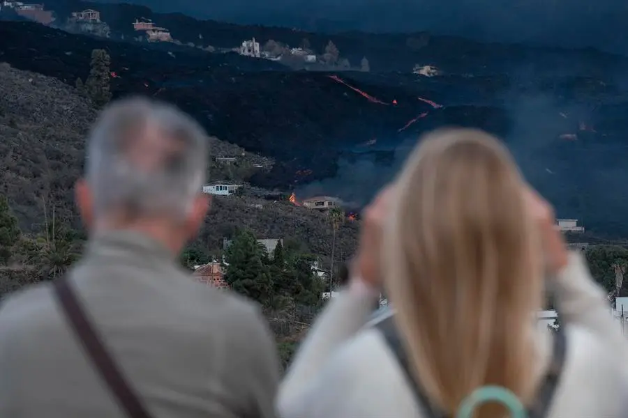 Vista del volc&aacute;n y la colada desde el municipio de Tazacorte, en la isla de La Palma, este viernes. Las pr&oacute;ximas horas ser&aacute;n decisivas para conocer el futuro de La Laguna y de otros barrios adyacentes, tanto de Los Llanos de Aridane como del vecino Tazacorte, evacuados desde el pasado mi&eacute;rcoles ante el incierto avance de la lava. Las dos coladas que el mi&eacute;rcoles avanzaron con velocidad y se unieron en una sola en el barrio de La Laguna est&aacute;n pr&aacute;cticamente "paradas" pero est&aacute;n recibiendo "mucho aporte de lava" en su parte trasera, tal y como confirman las c&aacute;maras termogr&aacute;ficas. El comit&eacute; cient&iacute;fico del Plan de Emergencias Volc&aacute;nicas de Canarias (Pevolca) prev&eacute; que tarde o temprano esas coladas, que han ido ganando en altura y anchura, prosigan su aproximaci&oacute;n al mar. EFE/ Angel Medina G.