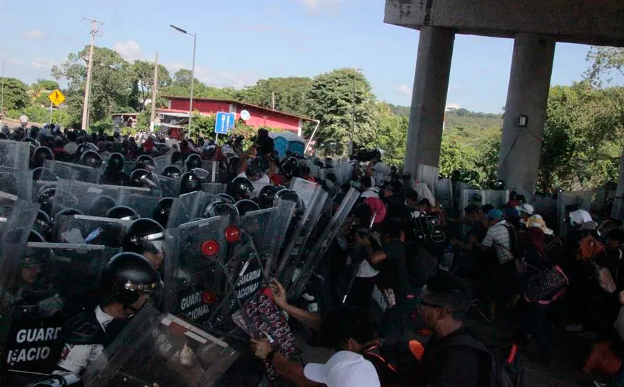 Miembros de la Guardia Nacional chocan con un grupo de migrantes al intentar detener su caravana en el tramo carretero Tapachula- Viva M&eacute;xico, hoy, en el estado de Chiapas (M&eacute;xico). EFE/ Juan Manuel Blanco