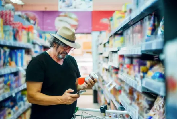 Una persona ojea un productor en un supermercado.
