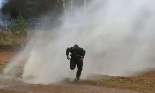 Un hombre huye de un ca&ntilde;&oacute;n de agua utilizado por agentes de la ley polacos en la frontera entre Belar&uacute;s y Polonia. Fotograf&iacute;a: Leonid Shcheglov / Belta / AFP / Getty