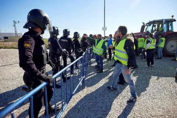 Agentes de la Polic&iacute;a Nacional durante los enfrentamientos con algunos de los manifestantes de la tractorada que este mi&eacute;rcoles han convocado los ganaderos de vacuno de leche en Talavera de la Reina (Toledo), para protestar por los precios bajos que reciben los productores por la leche a la empresas.EFE/ Manu Reino
