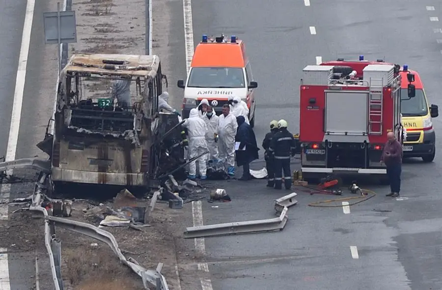 Bomberos, polic&iacute;as e investigadores inspeccionan los restos de un autob&uacute;s con matr&iacute;cula de Macedonia del Norte que se incendi&oacute; tras estrellarse en una carretera, causando la muerte de al menos 45 personas, cerca de la localidad de Bosnek (Bulgaria), el 23 de noviembre de 2021. (Incendio) EFE/EPA/VASSIL DONEV