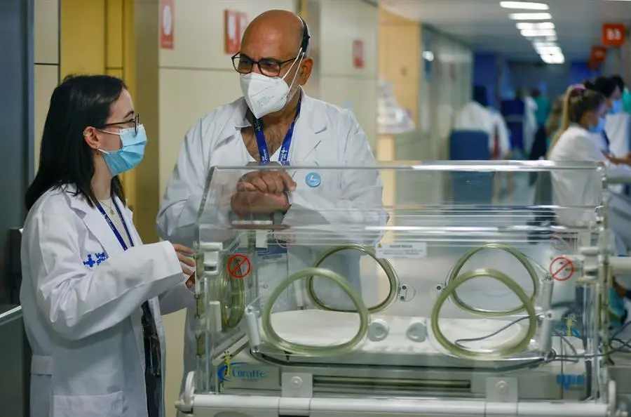 Noelia Ruiz (i), apenas pes&oacute; 800 gramos al nacer con tan solo 24 semanas de gestaci&oacute;n, pero sobrevivi&oacute; sin secuelas tras pasar tres meses en la incubadora gracias a los cuidados, entre otros, del jefe de Neonatolog&iacute;a del Hospital Vall d,Hebr&oacute;n, F&eacute;lix Castillo (d), con quien se ha reencontrado 24 a&ntilde;os despu&eacute;s trabajando como auxiliar de enfermer&iacute;a en el mismo hospital. EFE/Toni Albir