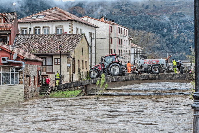 Vecinos, trabajadores de la zona y tractores trabajando en las labores de desag&uuml;e y limpieza de sus establecimientos tras las inundaciones de ayer. / TONO REGUERA