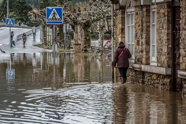 Vecinos, trabajadores de la zona y tractores trabajando en las labores de desag&uuml;e y limpieza de sus establecimientos tras las inundaciones de ayer. / TONO REGUERA