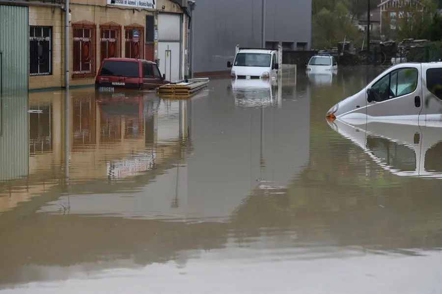 Varios veh&iacute;culos permanecen bajo el agua en el poligono industrial de Ampuero este lunes, debido a la crecida del r&iacute;o As&oacute;n.- EFE/Pedro Puente Hoyos