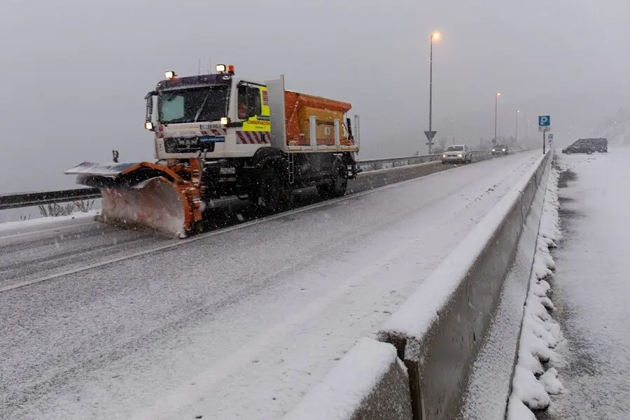 Una m&aacute;quina quitanieves quitando nieve de las carreteras.