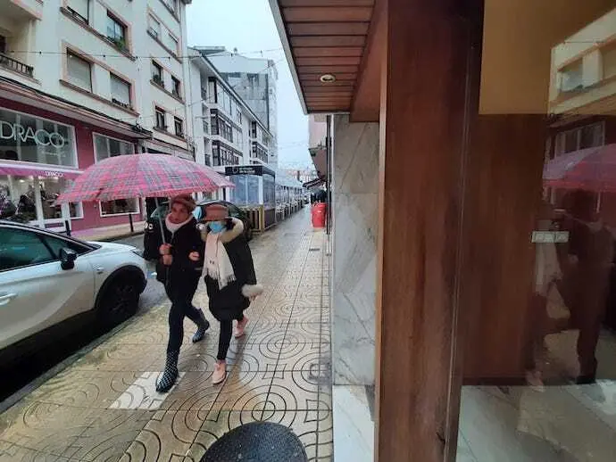 Dos personas con y sin mascarilla por Torrelavega.