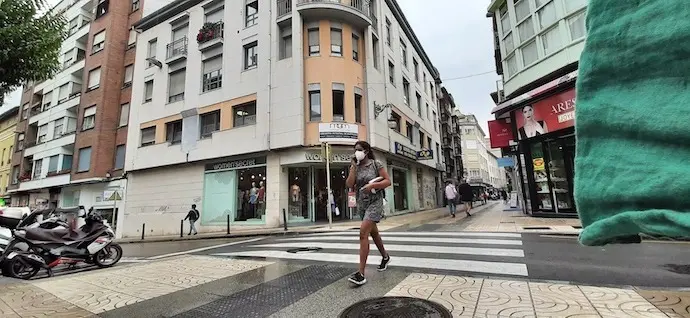 Una mujer con su m&oacute;vil transita por la calle Consolaci&oacute;n de Torrelavega. / ALERTA