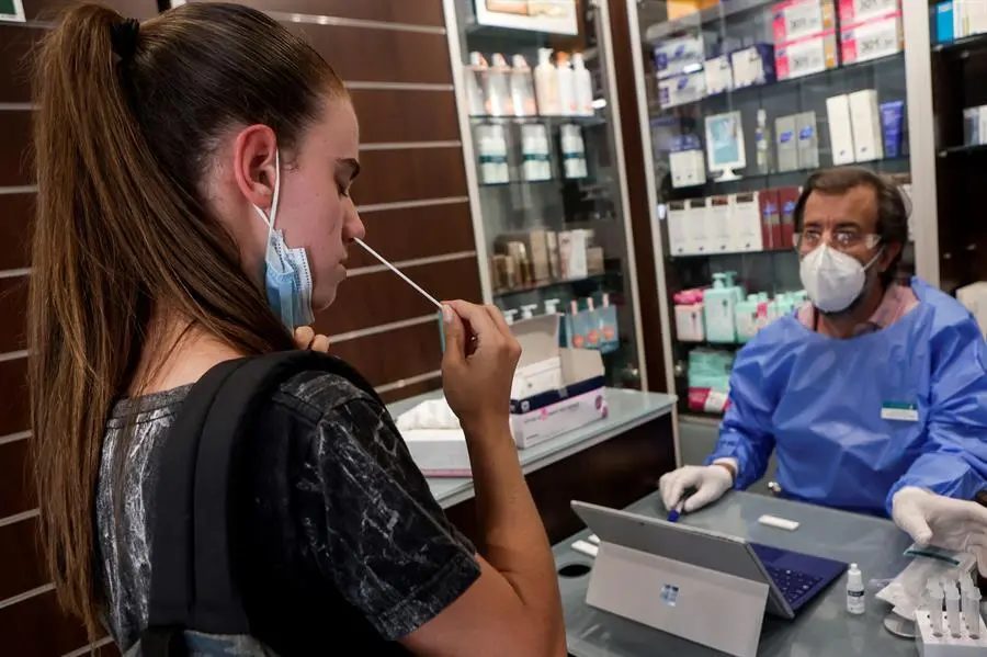 Un farmac&egrave;utico explica y supervisa la realizaci&oacute;n de autotests de ant&iacute;genos en una imagen de archivo. EFE/Quique Garcia
