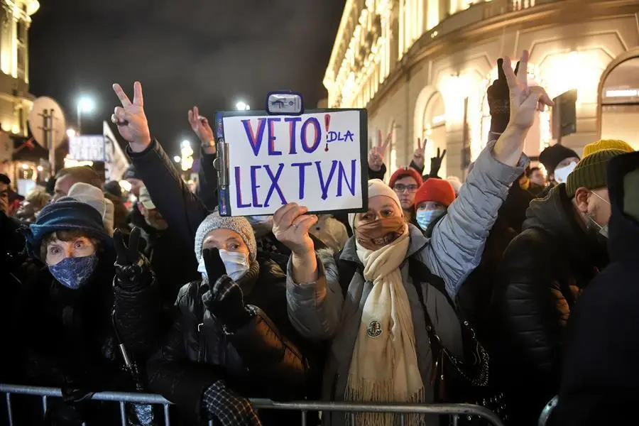 Simpatizantes y miembros de partidos de la oposici&oacute;n participan en una protesta contra la nueva ley de medios de comunicaci&oacute;n en Varsovia, Polonia, el 19 de diciembre de 2021. La C&aacute;mara Baja del Parlamento polaco (Sejm) aprob&oacute; el 18 de diciembre un proyecto de ley. La nueva normativa, que obliga a los propietarios de medios de comunicaci&oacute;n ajenos al Espacio Econ&oacute;mico Europeo a vender sus participaciones mayoritarias en las empresas medi&aacute;ticas polacas y limita su nivel de propiedad al 49 por ciento, afectar&aacute; a la cadena de televisi&oacute;n TVN, que es propiedad del gigante medi&aacute;tico estadounidense Discovery. (Protestas, Polonia, Varsovia) EFE/EPA/Radek Pietruszka