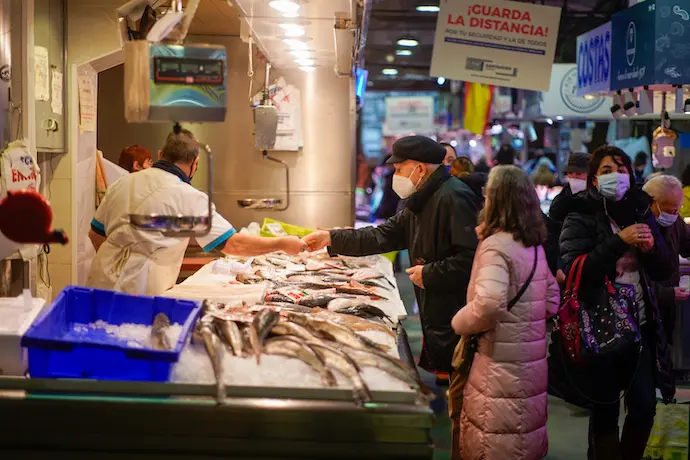 Varias personas en el mercado de Santander ultimando las compras de Navidad. / Hardy