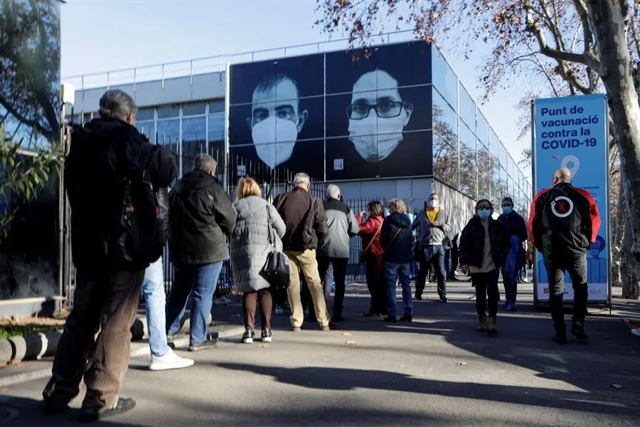 Decenas de ciudadanos guardan su turno en cola para accecer al centro de vacunaci&oacute;n instalado en la Fira de Barcelona este lunes. EFE/Quique Garcia