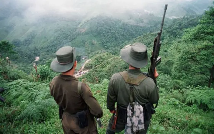 Dos soldados armados de las Fuerzas Armadas Revolucionarias de Colombia (FARC) vigilan el paso de Berl&iacute;n.