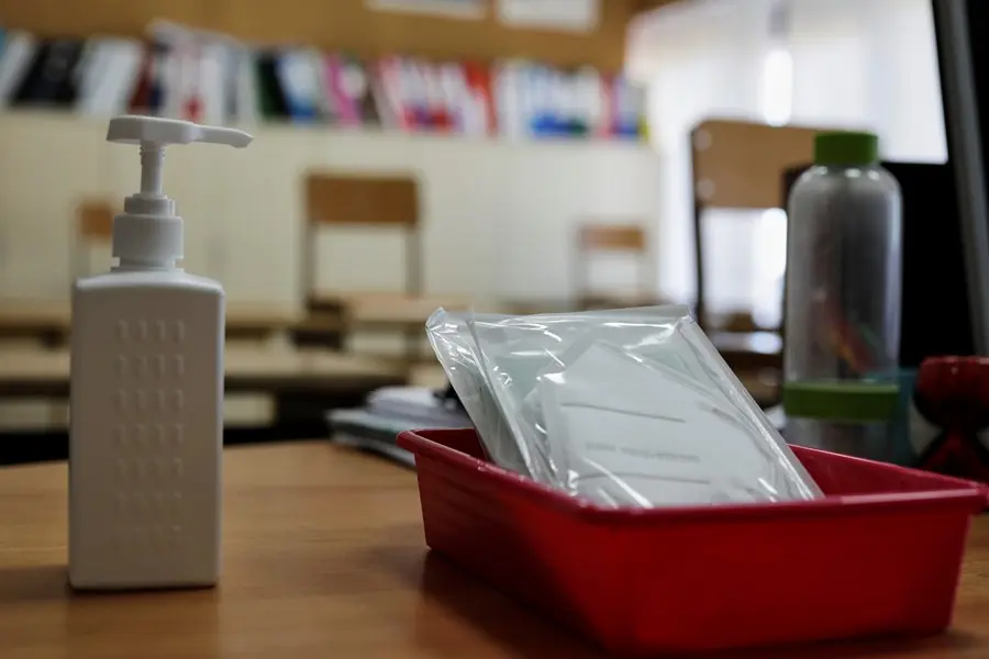 Mascarillas y gel desinfectante en la mesa de profesor de un aula. / EP