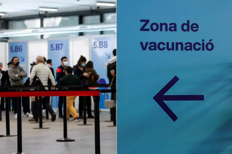 Decenas de ciudadanos guardan su turno en cola para accecer al centro de vacunaci&oacute;n instalado en la Fira de Barcelona, en una fotograf&iacute;a de archivo. EFE/Quique Garcia