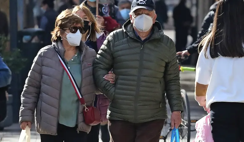 Varias personas transitan con su mascarilla.