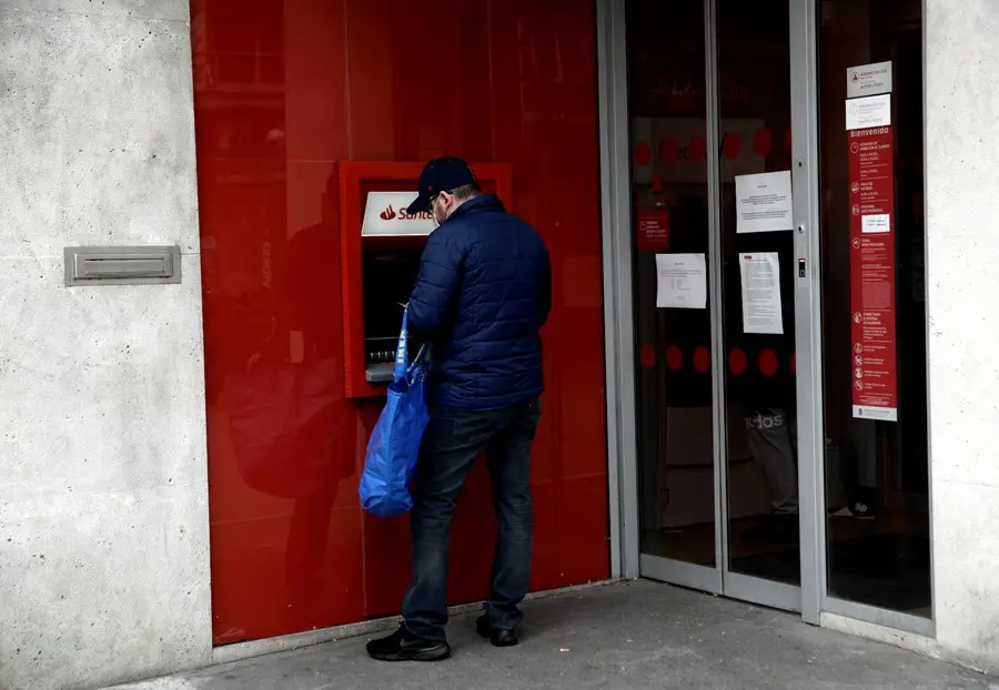 Un hombre saca dinero de un cajero del Banco Santander. / EP